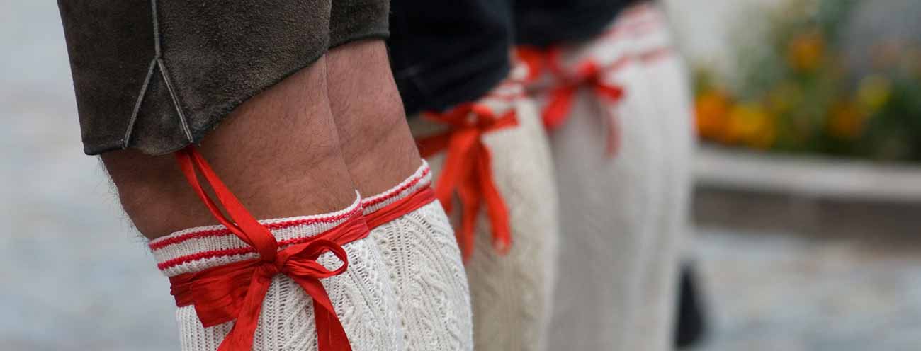 Gambe di uomini in costume tipico sudtirolese in primo piano