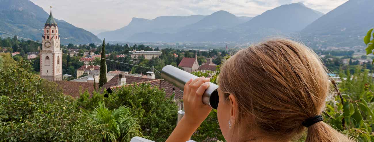 Girl look with a telescope at the Church of St. Leonhard