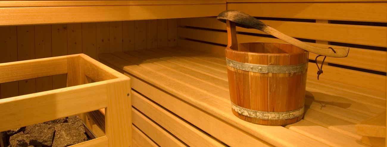 Close up of the water bucket and the benches of the sauna in Königsrainer