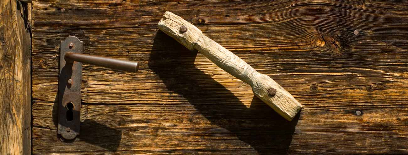 Vecchia porta di legno con manico in legno e ghisa