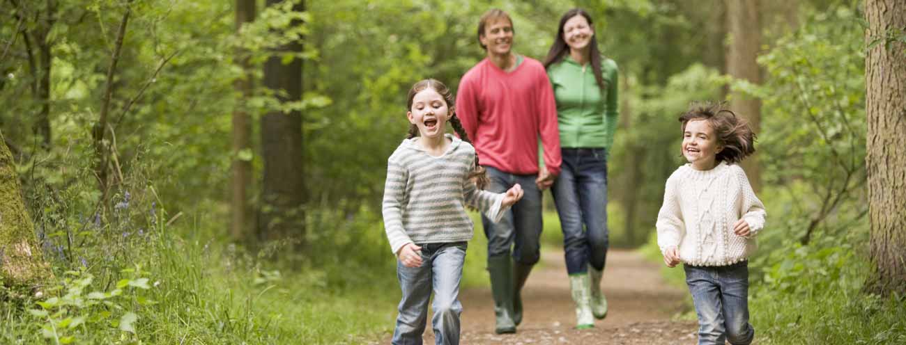 Smiling family on a forest trail hiking