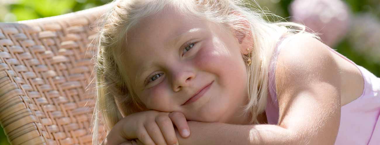 Contented blond girl while resting on a deck chair