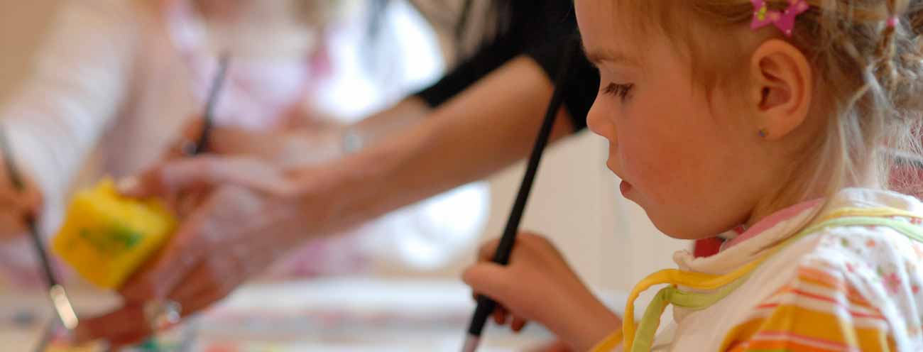 Girl with brushes in hand while painting