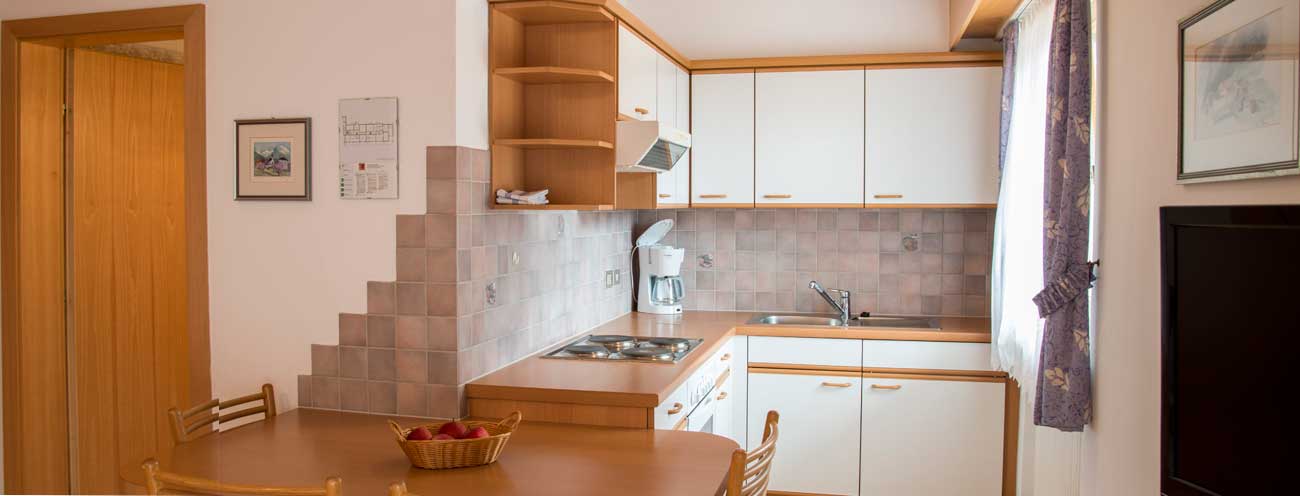 Die Küche in einem Apartment vom Residence Königsrainer mit grauen Fliesen
