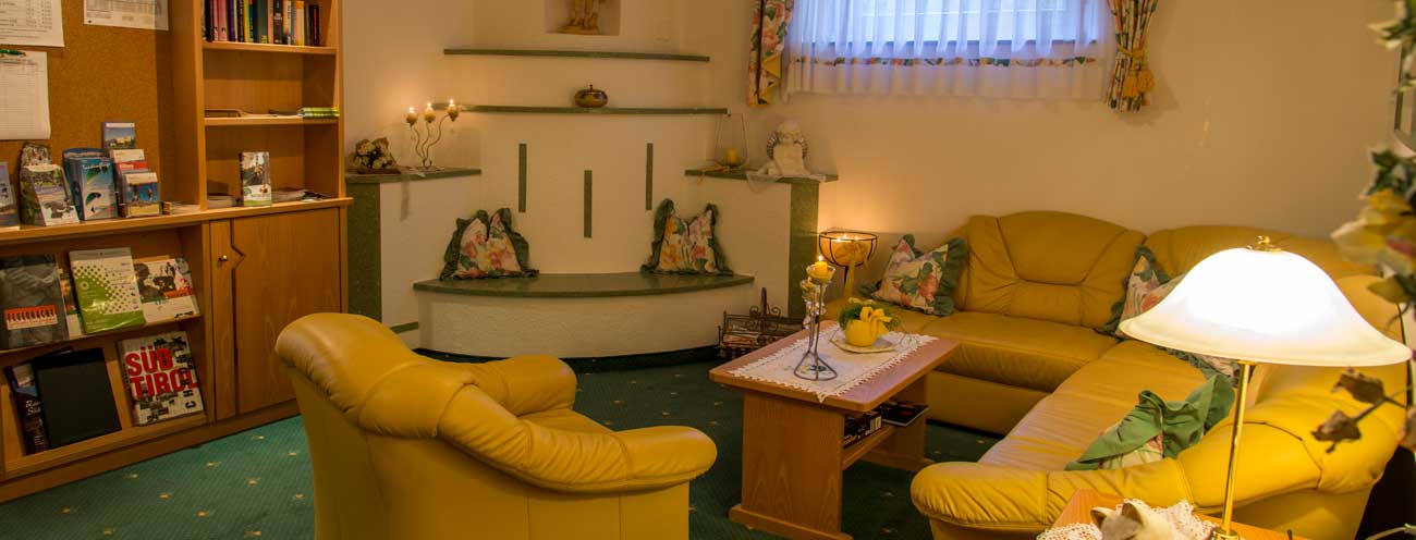 Living room in the main house of the Königsrainer with closed fireplace and sofas