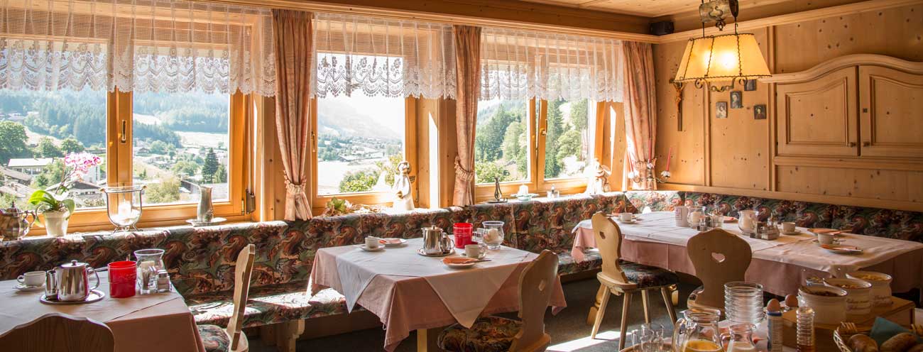 Sala per la colazione rivestita in legno con tavoli apparecchiati