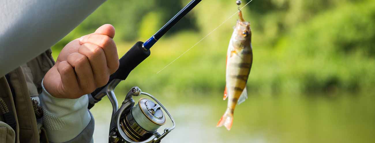 Pescatore mentre pesca con un pesce sull'amo