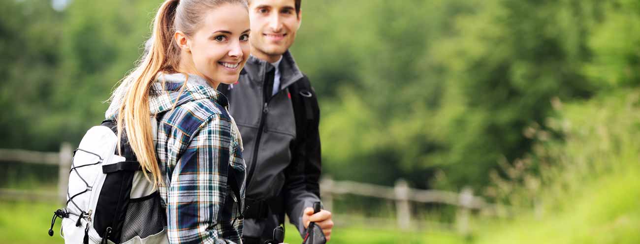 Paar mit Bergausrüstung beim Rasten während einer Wanderung