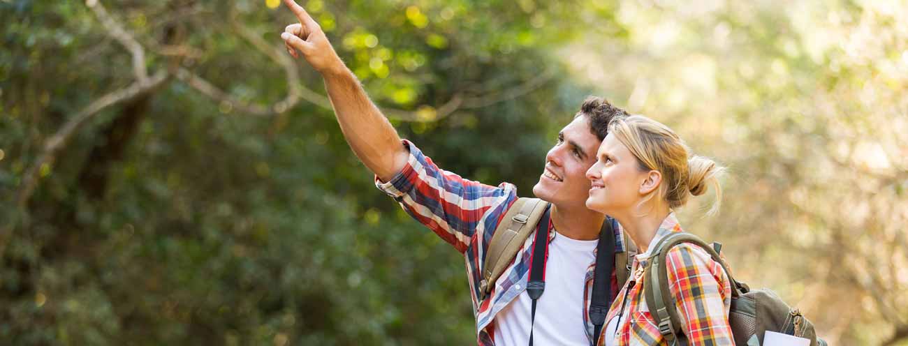 A couple on a hike in the middle of a sunny forest in Passeiertal