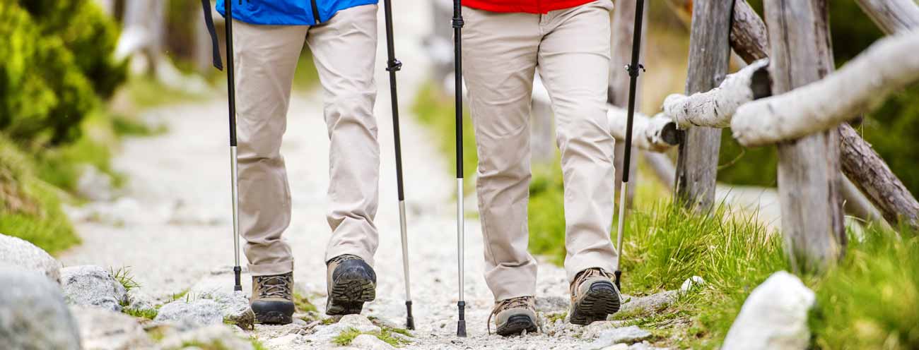 Closeup of two hikers on a fenced footpath